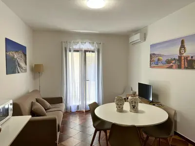 a living room with a table and a couch at Appartamenti-Residence Al Massimo in Palermo