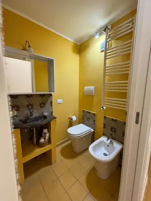 a dining room with a table and yellow chairs at Casa di Cocò in Palermo