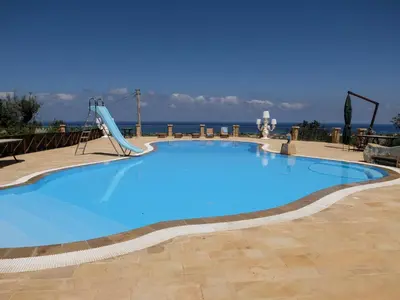 a large blue swimming pool with a slide at Terrazze sul Tirreno in Lascari