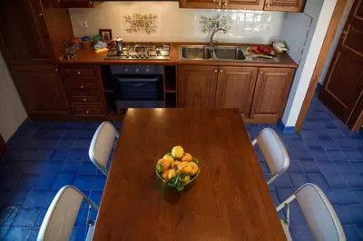 a kitchen with a wooden table with a bowl of fruit on it at Terrazze sul Tirreno in Lascari