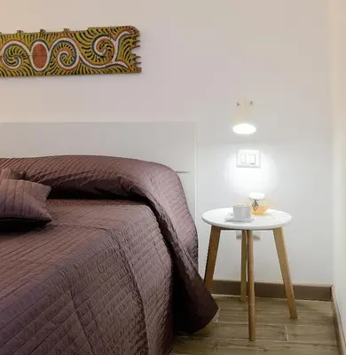 a bed and a table with a coffee cup on it at Alla Corte Maqueda in Palermo
