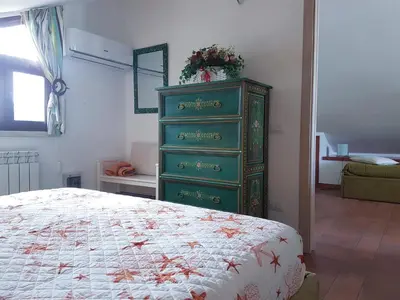 a green dresser in a bedroom with a bed at Mansarda con Vista Piscina in Campofelice di Roccella