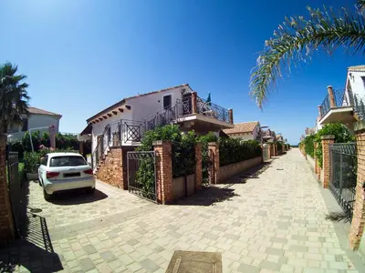 a car parked in front of a house with a driveway at Mansarda con Vista Piscina in Campofelice di Roccella