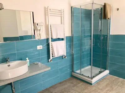 a bathroom with a glass shower and a sink at Mondello Beach Rooms - by the sea in Mondello