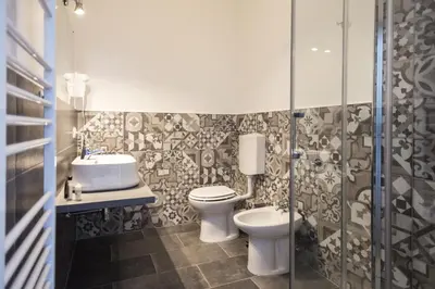 a bathroom with two toilets and a sink and a shower at Mondello Beach Rooms - by the sea in Mondello