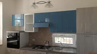 a kitchen with blue cabinets and a sink at Casa Vacanze Reginotte in Balestrate
