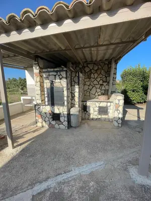 a stone fireplace under a roof on a patio at Casa Vacanze Reginotte in Balestrate
