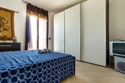 a bedroom with a blue bed and a television at Villa Mare Ficarazzi in Ficarazzi