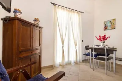 a living room with a dresser and a table and a window at Villa Mare Ficarazzi in Ficarazzi