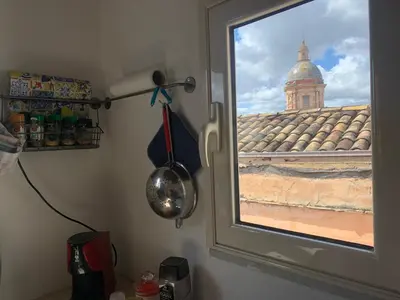 a dining room table with chairs and a yellow refrigerator at Casa pergj in Palermo