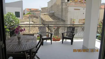 a balcony with three chairs and a table on a balcony at La sterlizia in Mondello