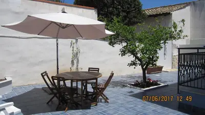 a table and chairs with an umbrella on a patio at La sterlizia in Mondello