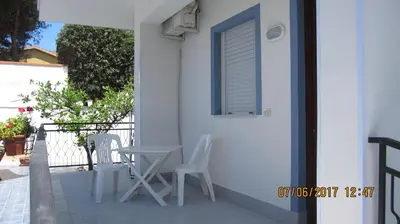 a patio with two chairs and a table and a window at La sterlizia in Mondello