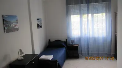 a bedroom with a blue bed and a window at La sterlizia in Mondello