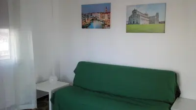 a green couch in a room with two pictures on the wall at La sterlizia in Mondello