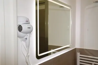 a hair dryer and a mirror in a bathroom at 315 Via Roma Rooms centro in Palermo