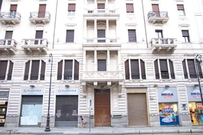 a white building with a door on a city street at 315 Via Roma Rooms centro in Palermo