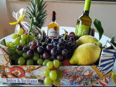 a bunch of grapes and bottles of wine on a table at Summer Dream LA CASA SUL MARE in Trappeto