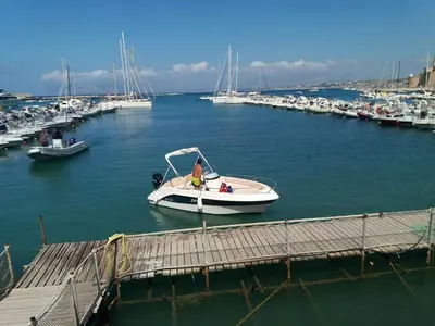 a group of people laying on a beach in the water at Maui apartament in Alcamo