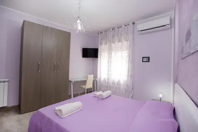 a bedroom with a purple bed with two towels on it at B&B Palermo Sole & Cultura in Palermo