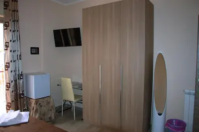 a room with a large wooden cabinet next to a table at B&B Palermo Sole & Cultura in Palermo