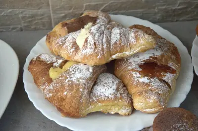 four pastries on a plate on a table at B&B Palermo Sole & Cultura in Palermo