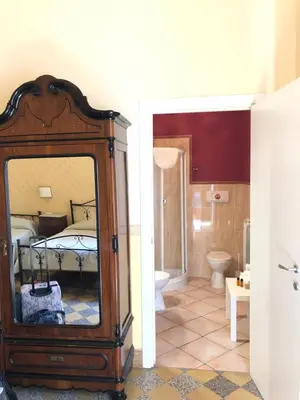 a bathroom with a mirror and a bedroom with a bed at B&B Dimora Annulina in Palermo