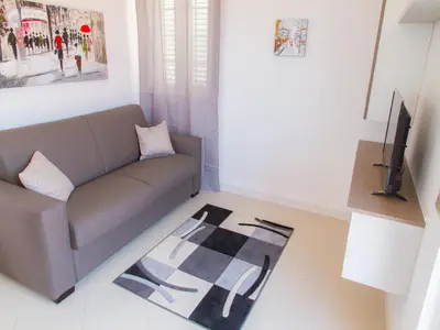 a living room with a couch and a television at Gelso Bianco Apartments in Campofelice di Roccella