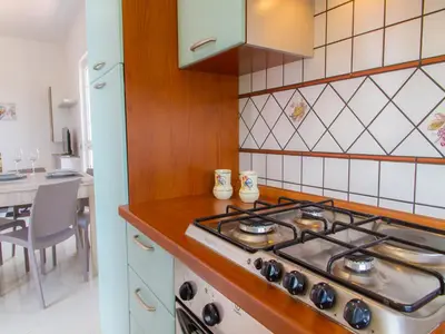 a kitchen with a stove and a counter top at Gelso Bianco Apartments in Campofelice di Roccella