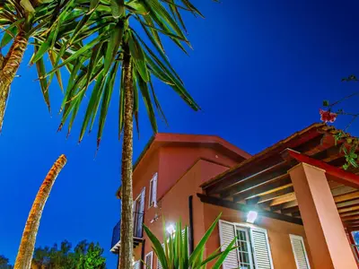 a house with palm trees in front of it at Gelso Bianco Apartments in Campofelice di Roccella