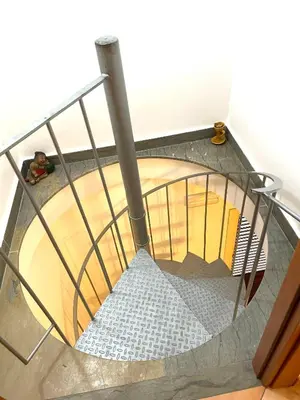 a spiral staircase in a house with a metal railing at La Rosa Blu in San Vito lo Capo