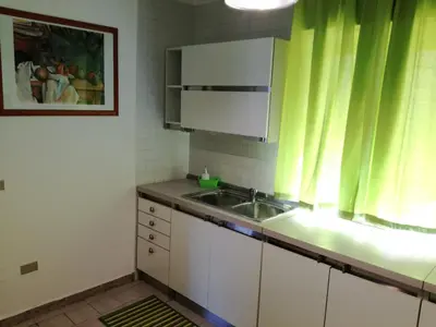 a kitchen with a sink and a green curtain at Sunset Flat in Isola delle Femmine