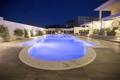 a large swimming pool at night with lights at Villa Del Mare in Alcamo Marina