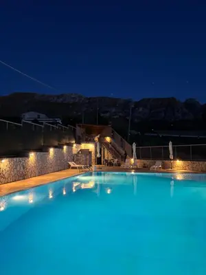 a large swimming pool at night with lights at Kairos B&B in San Giuseppe Jato
