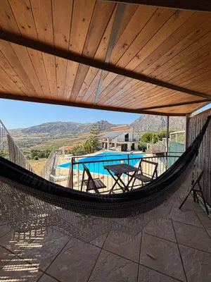 a hammock on a patio with a view of a pool at Kairos B&B in San Giuseppe Jato
