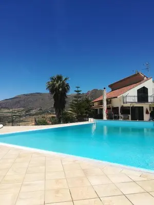 a large blue swimming pool in front of a house at Kairos B&B in San Giuseppe Jato