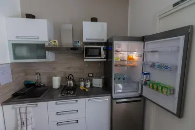a small kitchen with a refrigerator and a microwave at Casantò guest home in Palermo