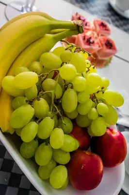 a plate of fruit on a table with bananas and apples at Casantò guest home in Palermo