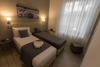a hotel room with two beds and a small stool at Casantò guest home in Palermo