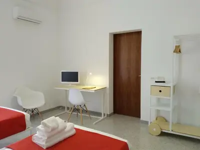 a bedroom with a bed and a desk with a computer at COLORI di PALERMO in Palermo