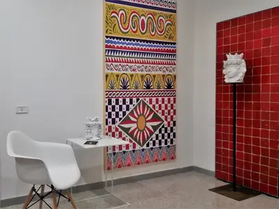 a table and a chair in a room with a rug at COLORI di PALERMO in Palermo
