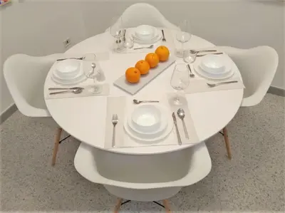a white table with glasses and plates and oranges on it at COLORI di PALERMO in Palermo