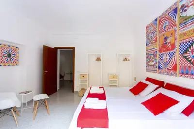 a bedroom with a large white bed with red pillows at COLORI di PALERMO in Palermo