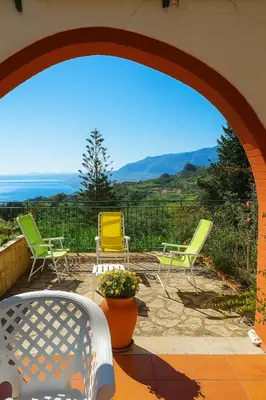 a patio with chairs and a view of the ocean at Maison de Soleil in Scopello