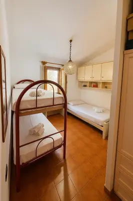 a room with two bunk beds and a kitchen at Maison de Soleil in Scopello