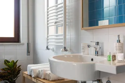 a white bathroom with a sink and a mirror at Mondello Martini in Mondello