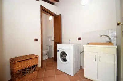 a bathroom with a washing machine and a toilet at Dependence Desiree in Alcamo