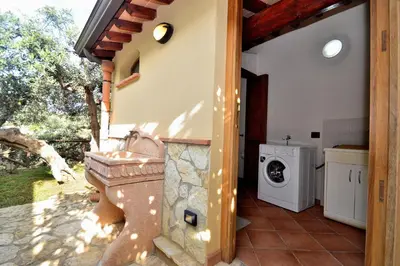 a bathroom with a washing machine next to a house at Dependence Desiree in Alcamo