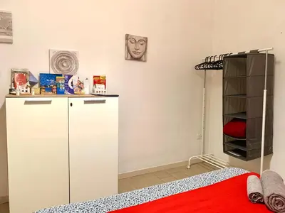 a bedroom with a white cabinet and a red bed at Bruno and Breakfast in Palermo
