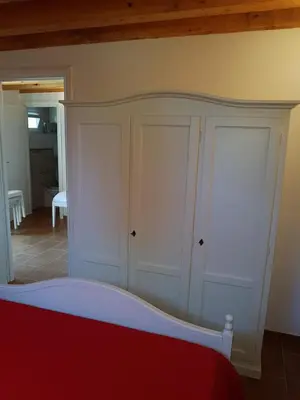 a bedroom with white cabinets and a red bed at Suite Panoramic in Porticello